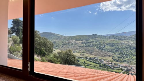 Vista do terraço do quarto de luxo da Quinta das Susandas com vista para as colinas verdes e vale em Tresouras, Portugal