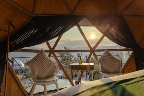 Interior de domo de glamping en Meraki Glampings Malinalco con vistas a la montaña, estructura de madera, asientos cómodos y zona exterior