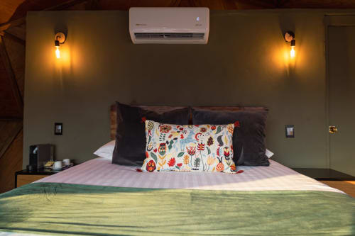 Acogedora habitación en Domo Standard de Meraki Glampings, Malinalco, con aire acondicionado, apliques de pared y coloridos cojines