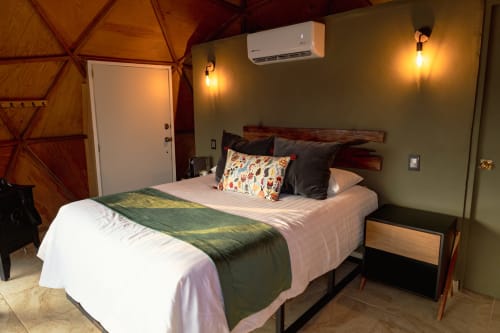 Habitación Domo en Meraki Glampings, Malinalco: cama queen, cabecera de madera rústica, aire acondicionado e iluminación cálida