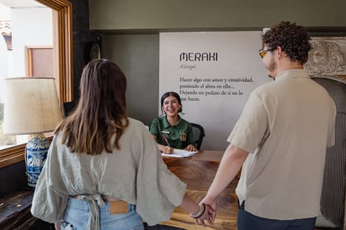 Personal del hotel asiste a huéspedes en la recepción de Meraki Glampings en Malinalco, México