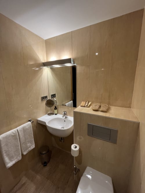 Modernes Badezimmer im Hotel Casa Azcona in Zizur Mayor mit beigefarbenen Fliesen, Waschbecken, Toilette und zeitgenössischen Armaturen