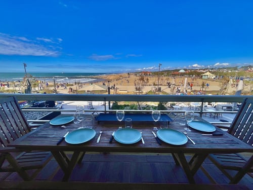 Beachfront dining table with blue plates overlooking Anglet beach and Atlantic Ocean, Golden Sand hotel