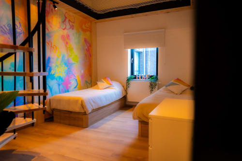 Chambre loft moderne au Hotel Grand Place, Mons avec deux lits, art mural coloré, escalier en bois et vue sur la ville