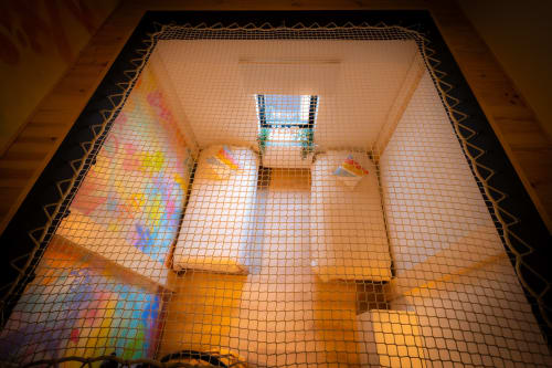 Intérieur de loft à l'Hôtel Grand Place avec projections lumineuses arc-en-ciel sur carrelage en terre cuite et plafond en maille