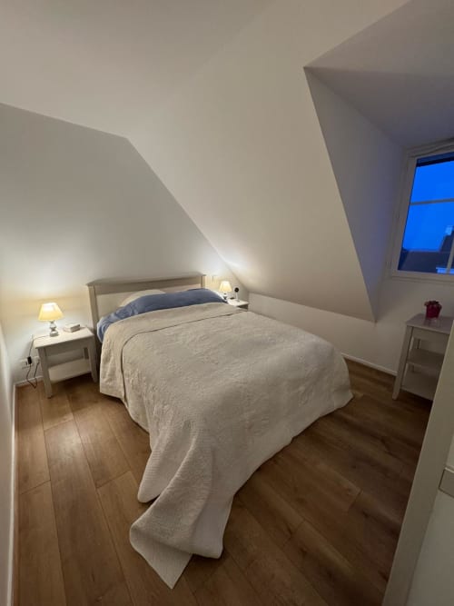 Chambre cosy sous les toits à Locmaria Belle-Île-en-Mer avec plafond mansardé, lit queen-size, lampes de chevet et lucarne