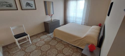 Bedroom at Tales of Abruzzo apartment in Atessa with bed, dresser, chair, and sea view window