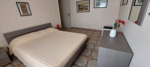 Modern bedroom at Tales of Abruzzo hotel in Atessa with striped bedding, flat-screen TV, and sea view apartment amenities