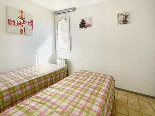 Chambre twin avec lits en housse à carreaux verts et roses à l'appartement Le Vallon des Sources à Digne-les-Bains