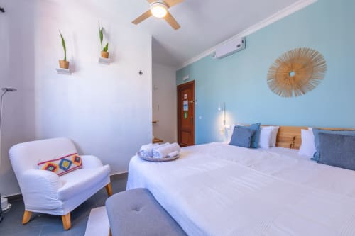 Levante room at Casa de Océano in Tarifa features modern décor with blue accent wall, white bed, and contemporary