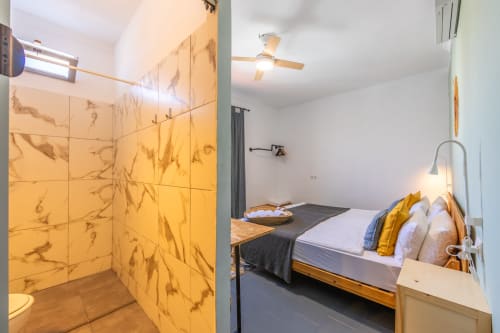 Gregal room at Casa de Océano in Tarifa featuring modern bathroom with yellow marble tiles and bedroom with wooden bed and