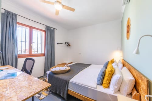 Gregal room at Casa de Océano hotel in Tarifa, Spain with bed, desk, window and ceiling fan