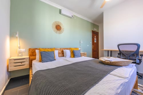 Gregal room at Casa de Océano hotel in Tarifa with blue accent wall, queen bed, wooden furnishings and modern workspace
