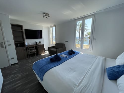 Spacieuse chambre d'hôtel au Hotel Flots d'Azur à Nice avec vue mer, TV, mobilier moderne et balcon