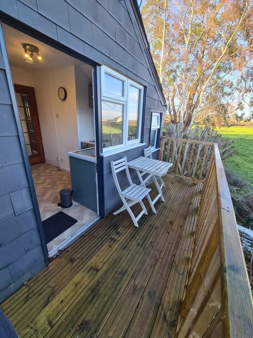 2 Doves Holiday Property deck with white chairs, table, and countryside views near Exeter, UK