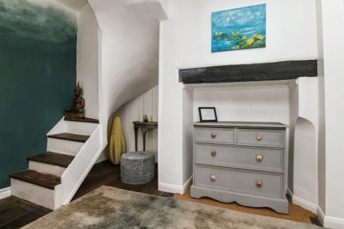 2 Doves Holiday Property staircase with gray dresser, wooden beam mantle, and water lily painting in Exeter