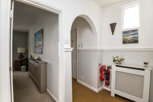 Modern hallway at 2 Doves Holiday Property in Exeter with white paneling, archway, and contemporary decor