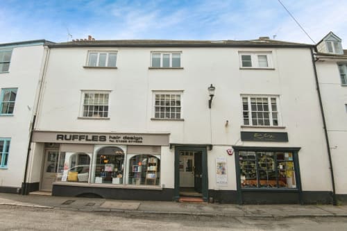 2 Doves Holiday Property storefront in Exeter with Ruffles hair design salon and shops on ground floor