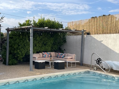 Salon au bord de la piscine à La Closerie, La Redorte - pergola avec sièges beige, petite piscine, terrasse en pierre
