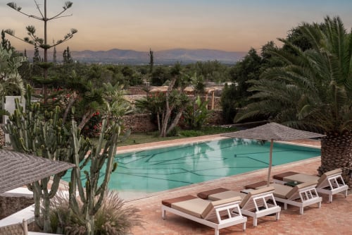 Piscine turquoise avec chaises longues avec vue sur l'Atlas au Domaine Belhazar, Essaouira