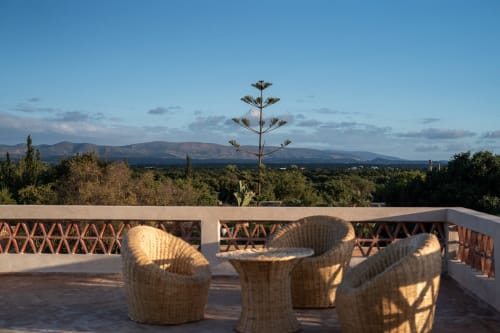 Rooftop terrace at Domaine Belhazar with woven chairs, mountain views, and agave plant in Essaouira