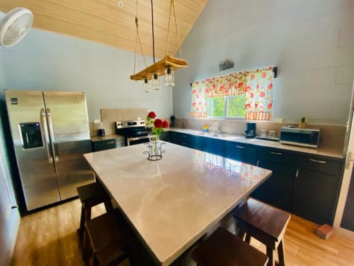 Moderna cocina y comedor en villa Casa de las Rosas con electrodomésticos de acero inoxidable y azules