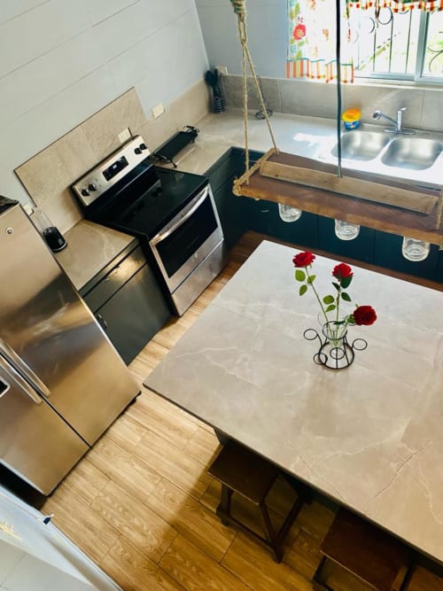Cocina moderna en la villa Casa de las Rosas, Cabinas Arenal Home, con electrodomésticos de acero inoxidable y zona de comedor
