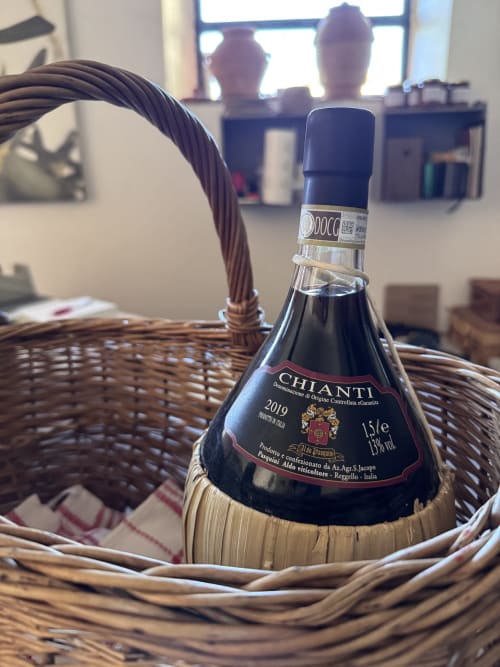 Bottiglia di vino Chianti in cesto di vimini presso l'Agriturismo San Jacopo, Reggello