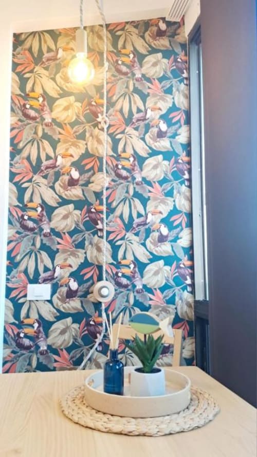 Farbenfrohe Blumentapeten-Akzentwand mit Pendelleuchte, Sukkulente im Topf und dekorativem Tablett in modernem Apartment auf Teneriffa.