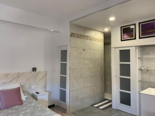 Modernes Badezimmer mit begehbarer Dusche, Marmor-Waschtisch und weißen Schränken im Apartment Salud Vacacional, Santa Cruz de Tenerife