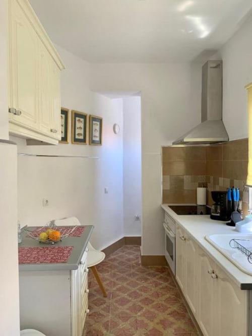 Moderne Küche im Apartment Salud Vacacional in Santa Cruz de Tenerife mit cremefarbenen Schränken, Edelstahlabzugshaube, braun