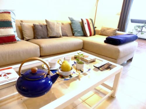 Cream sectional sofa with decorative pillows in Tabaiba Ocean View apartment, white coffee table with blue teapot and yellow