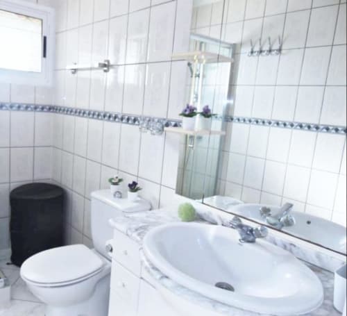 Modern bathroom with white tiles, double sink, toilet, and mirror in Tabaiba Ocean View apartment, Santa Cruz de Tenerife