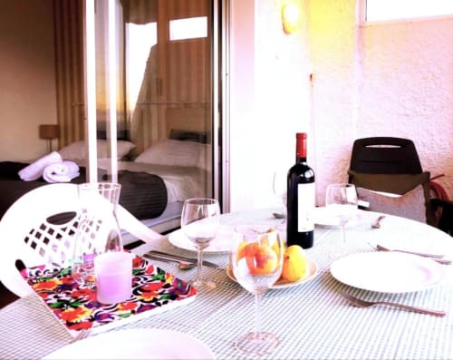 Dining area with ocean view in Tabaiba apartment, Santa Cruz de Tenerife, featuring wine bottle, fruit bowl, and access to