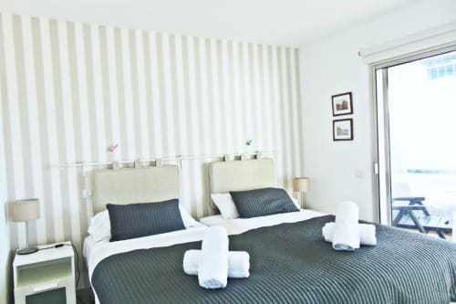 Modern twin bedroom in Tabaiba Ocean View apartment, Santa Cruz de Tenerife, with striped wallpaper and sea view from terrace