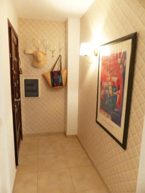 Narrow hallway in Tabaiba Ocean View apartment, Santa Cruz de Tenerife, with framed artwork and coat rack