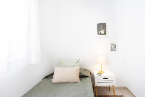 Minimalistisches Schlafzimmer im Vive La Vacacional Renting in Santa Cruz de Tenerife mit Einzelbett, weißem Nachttisch und moderner Wand