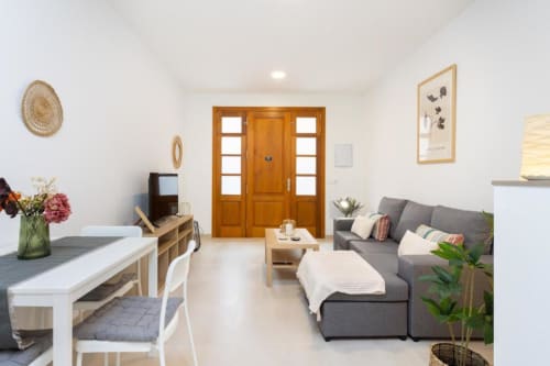 Modernes offenes Wohnzimmer und Küche in Santa Cruz de Tenerife mit grauem Sofa, Holzeingangstüren und Essbereich