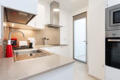 Moderne Küche im Apartment Triana Toscal, Santa Cruz de Tenerife, mit Edelstahlgeräten und weißen Schränken