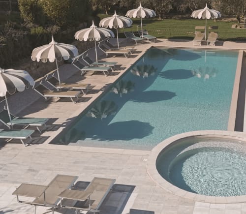 Lussuosa area piscina presso Agriturismo Il Serraglio a Montepulciano con lettini, ombrelloni e vasche idromassaggio