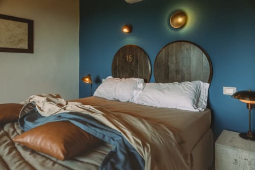 Camera moderna dell'Agriturismo Il Serraglio a Montepulciano con pareti blu, testata in legno, biancheria bianca e ottone