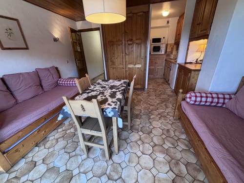 Studio apartment at Chez Francine with purple sofas, dining area, and wood furnishings in Notre Dame de Bellecombe