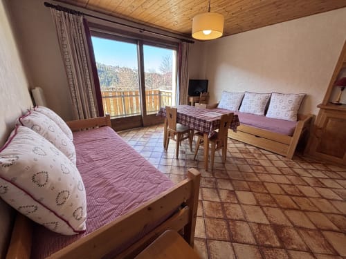 Studio apartment in Notre Dame de Bellecombe with two beds, wooden furnishings, balcony view of mountains, and modern