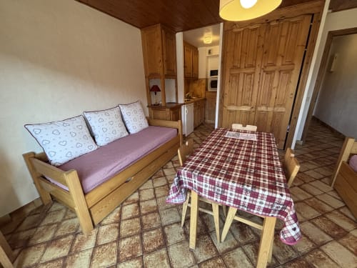 Studio apartment at Chez Francine with wooden sofa, dining table, kitchenette, and wardrobe in Notre Dame de Bellecombe