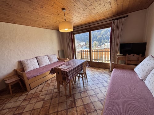 Studio apartment in Notre Dame de Bellecombe with wooden ceiling, sofa, bed, dining table, TV, and balcony overlooking