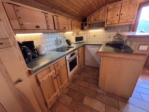 Fully equipped kitchen in Chez Francine apartment, Notre Dame de Bellecombe, with wooden cabinets, stainless steel