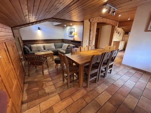 Cozy apartment dining and lounge area with wooden furnishings, beamed ceiling, and mountain views at Chez Francine, Notre