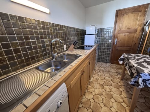 Kitchen in Appartement Mont Rond at Chez Francine, Notre Dame de Bellecombe, with dark tile backsplash, wooden cabinets, and