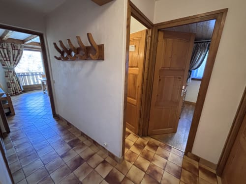 Hallway in Appartement Roc du Vent at Chez Francine with wooden doors, coat hooks, and tiled flooring