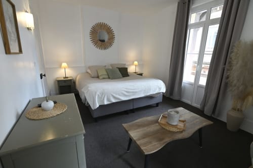 Chambre moderne au Gîte de la Petite Salamandre à Étretat avec lit, coin détente et portes-fenêtres